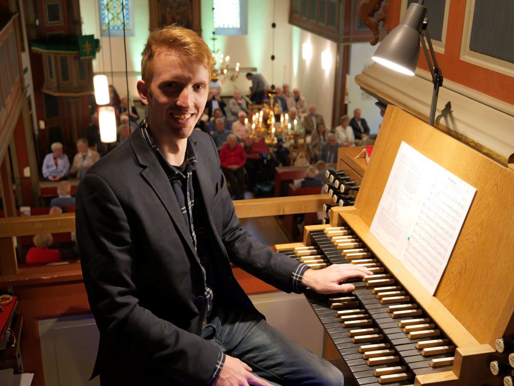 Lippischer Orgelsommer begeistert - Ausklang des Lippischen Orgelsommers in Bergkirchen. Leon Frederic Kleemeier brilliert an der Orgel mit Werken aus fünf Jahrhunderten. Organist sitzt in der Kirche an der Orgel. Im Hintergrund unten Publikum.