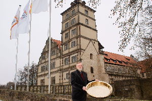 Größtes Tauffest in NRW - Festorganisator Pfarrer Rolf-Joachim Krohn-Grimberghe zeigt vor Schloss Brake die beim Tauffest zum Einsatz kommende Taufschale von St. Nicolai.